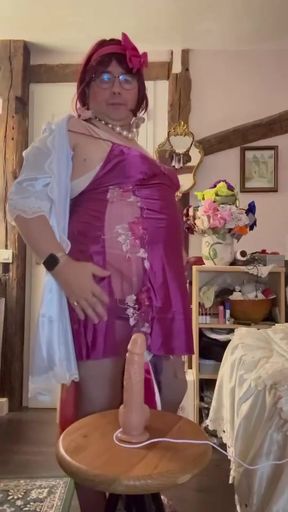 In an outfit with a little fuchsia nightie to suck a dildo at a party