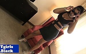 Stripteasing black shemale strokes her cock