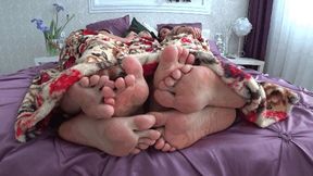 Three pairs of legs flirting under the blanket aFJ