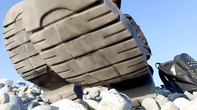 Domme in leather boots displays dirty soles up close for foot fetish fans