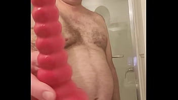 Nude Martin Lavall&eacute_e sodomizes himself with a red dildo and compares it with his black chastity device